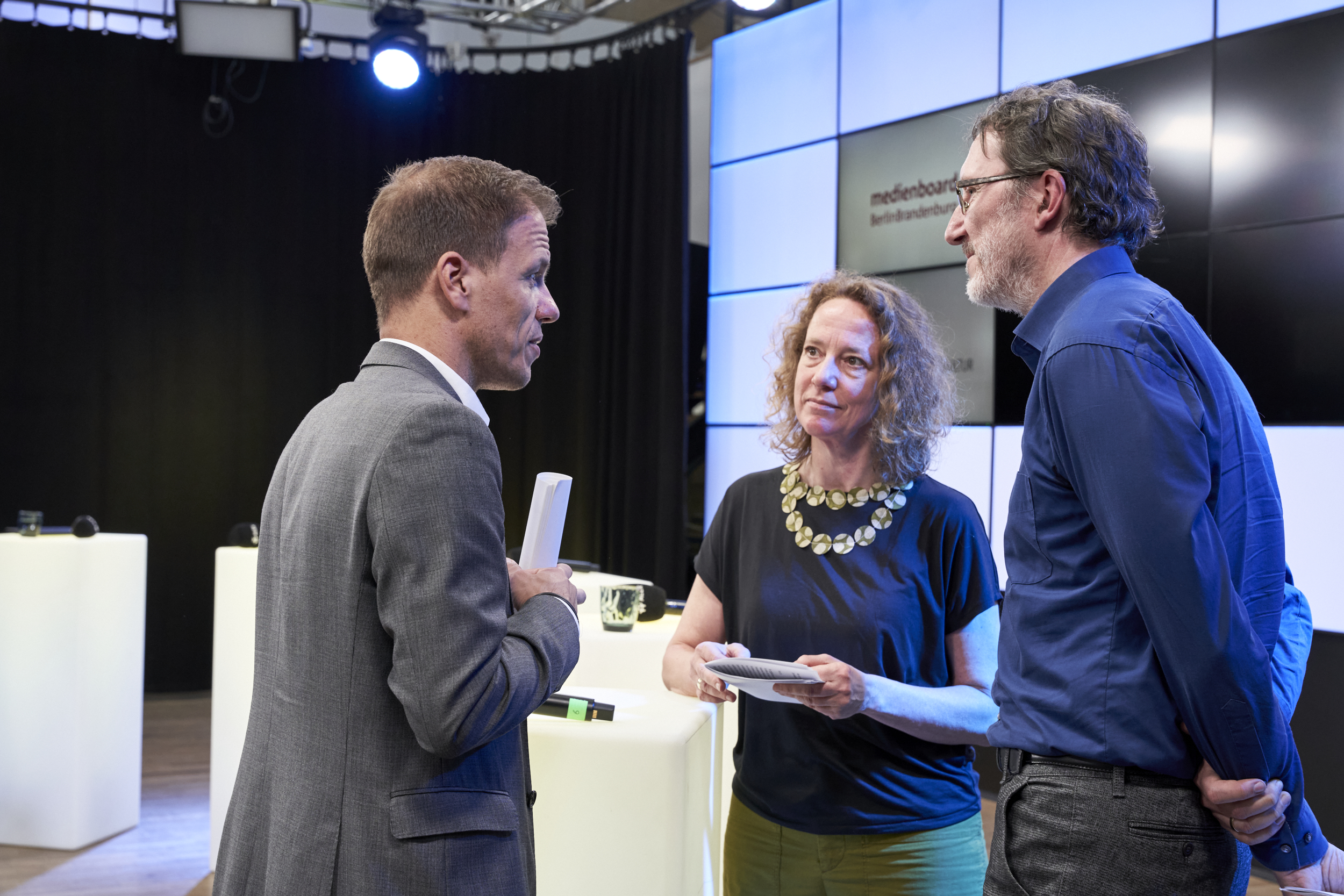 André Necke, Prof. Dr. Angela Tillmann und Michael Gurt (von links nach rechts) tauschen sich zwischen den Programmpunkten aus.